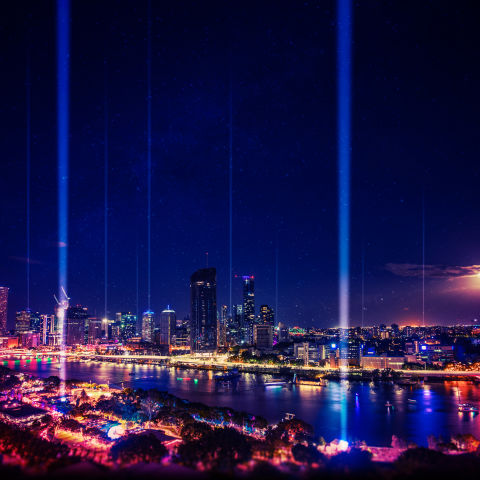 The Brisbane River and city lit up at night by Brisbane Festival's Sunsuper Night Sky. 
